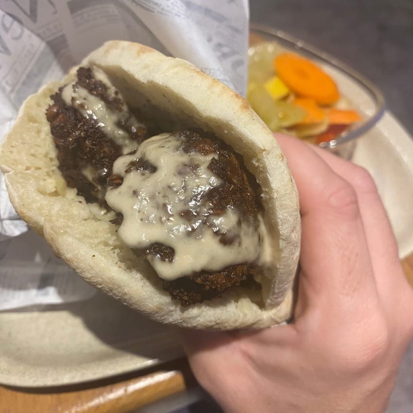 Falafel lathered in tahini packed into a pita bread