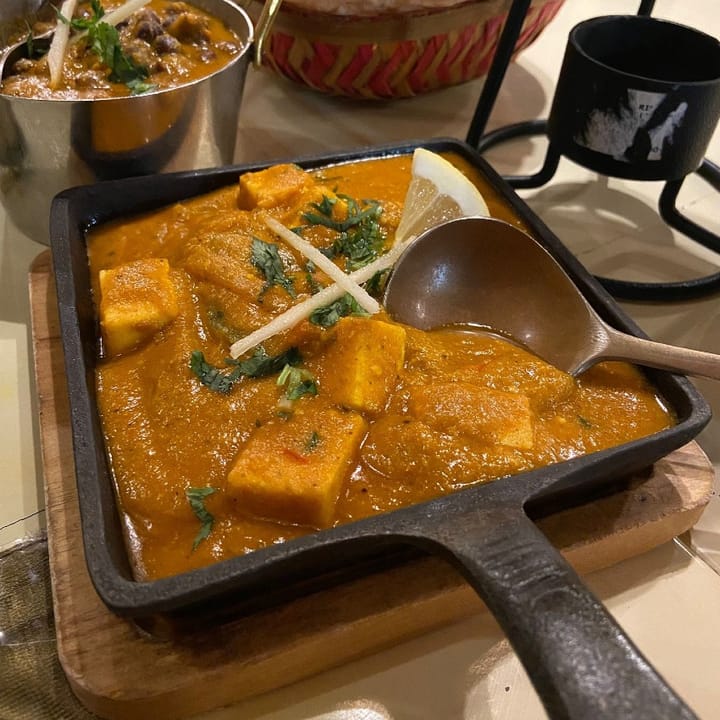 A rich paneer curry served in a cast iron skillet