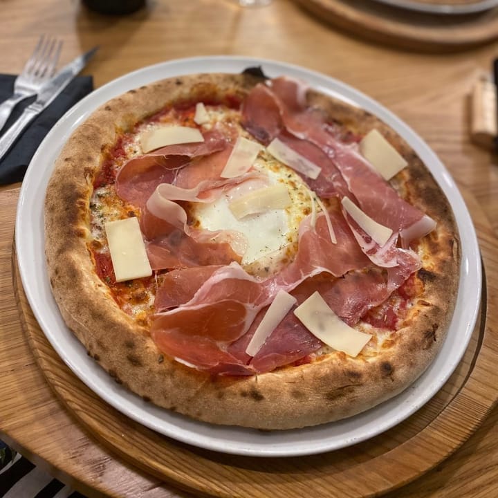 The Emilia pizza with a crunchy base, topped with presunto, parmesan, and a perfectly fried egg in the centre