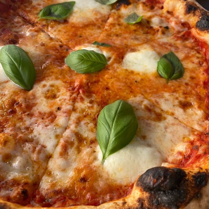 Classic Margherita pizza topped with mozzarella and fresh basil leaves
