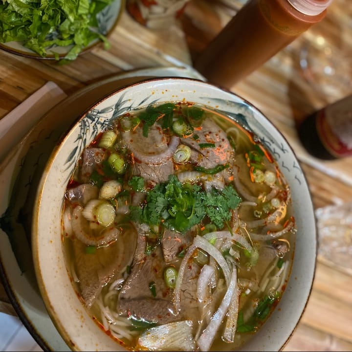 Large bowl of spicy beef noodle soup with rich broth and tender beef slices