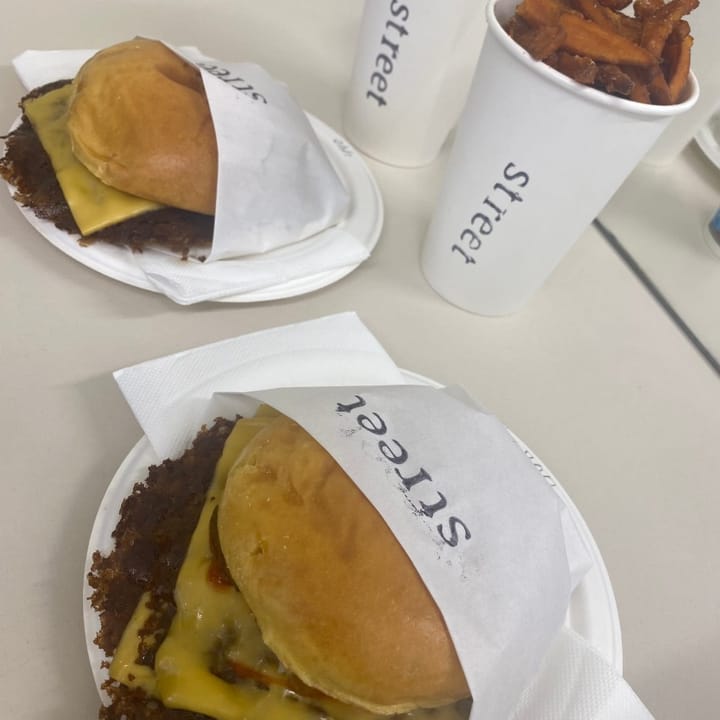 Two double smashburgers with cheese and cups of sweet potato fries