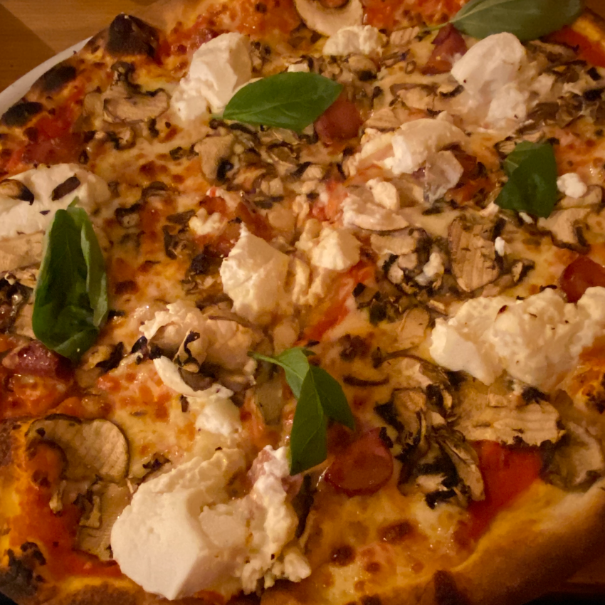 A fresh pizza loaded with chouriço, mushrooms and ricotta as toppings