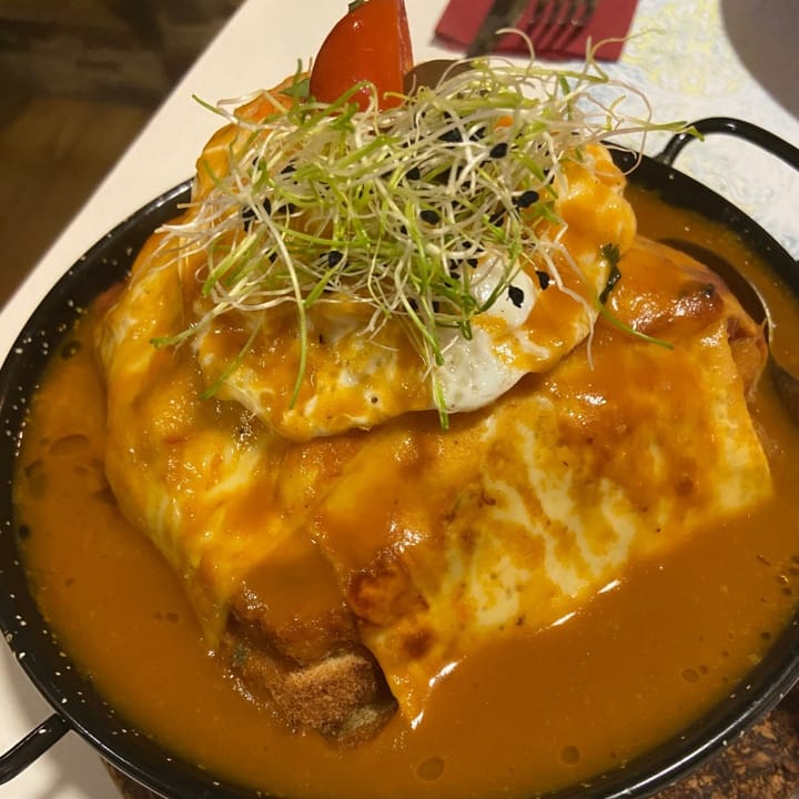 Francesinha. Layers of bread, meat & cheese, topped with an egg and drenched in gravy