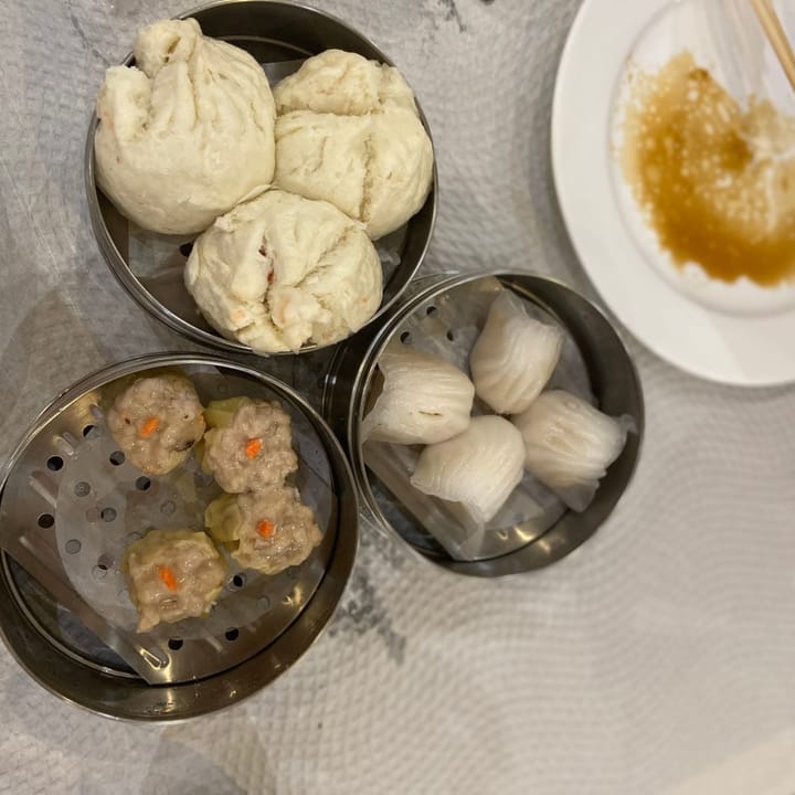 Fresh soft char siu bao, ha gow, and sui mai dim sum served in metal steamers