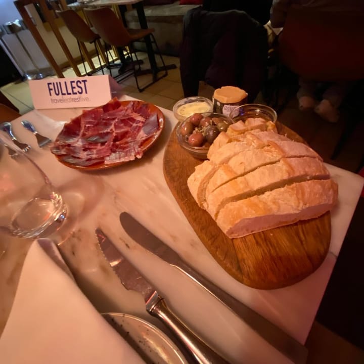 Plate of presunto with fresh bread, olives, and butter, a classic Portuguese appetizer