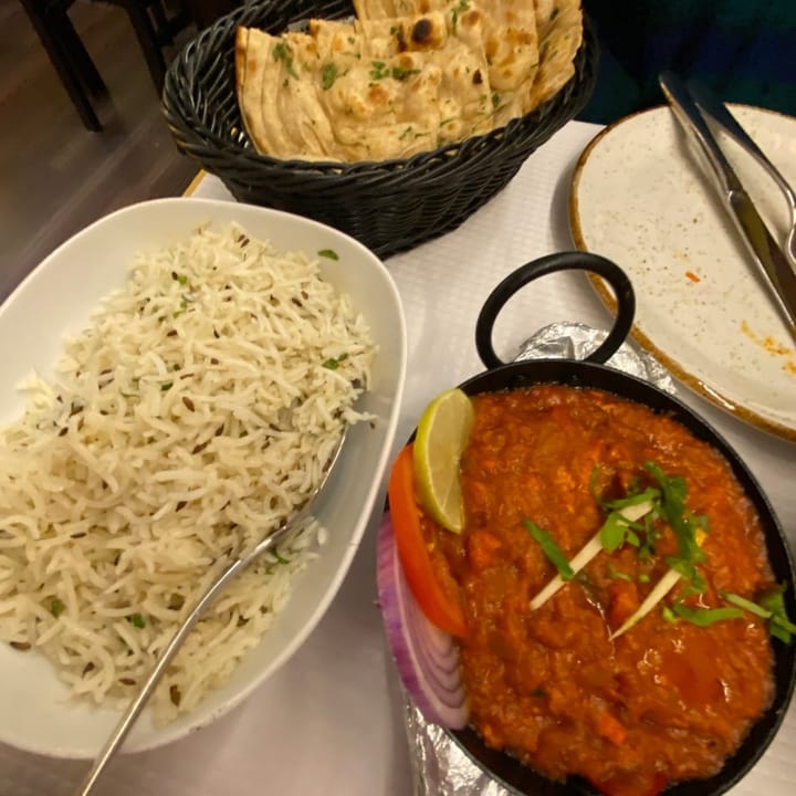 Spicy chicken jalfrezi curry served with fragrant basmati rice and warm naan bread, a flavorful and aromatic dish