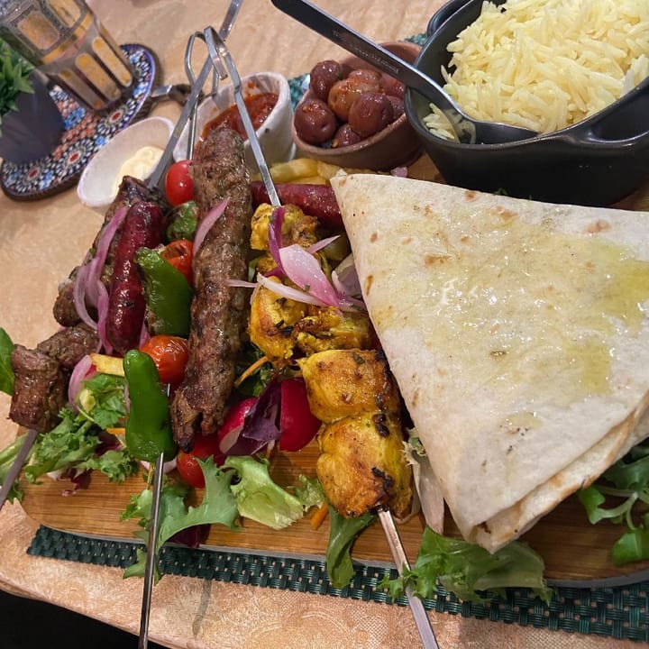A mixed grill with skewers of succulent lamb, chicken & sausage served with salad, bread & rice
