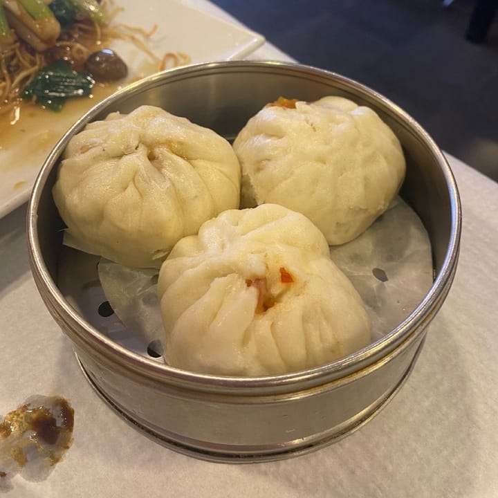 Freshly steamed char siu bao nestled snuggly in their metal steamer