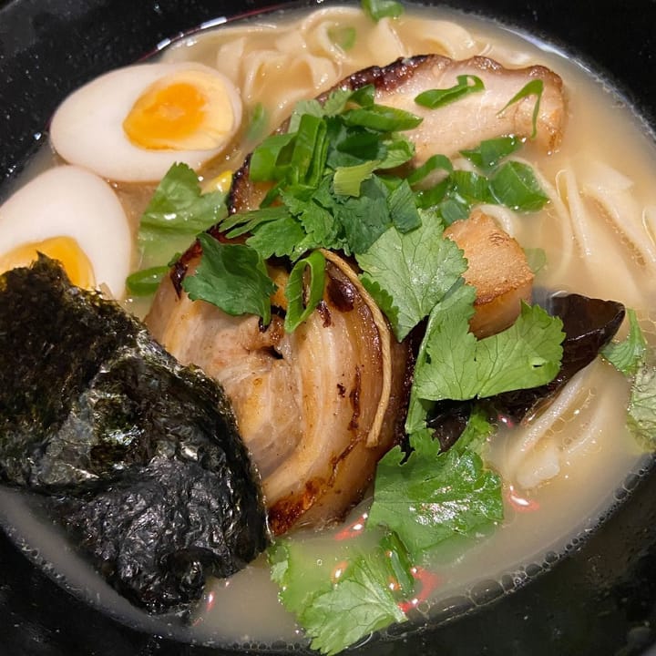 Bowl of pork belly ramen with coriander, hard boiled egg and seaweed
