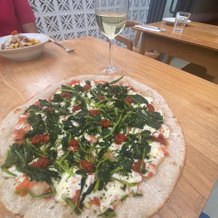The Santorini pizza topped with spinach, nduja, and mozzarella cheese