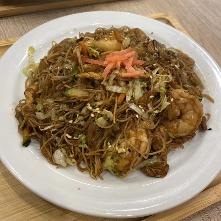 A plate of Prawn chow mein with vermicelli noodle and topped with pickled vegetables