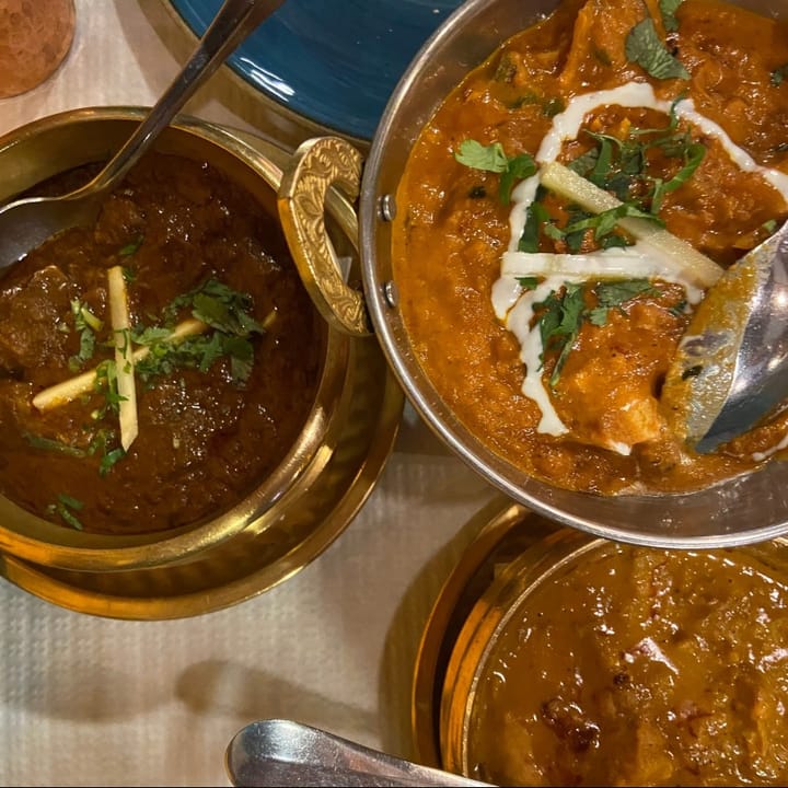 A selection of curries served in decorative metal bowls